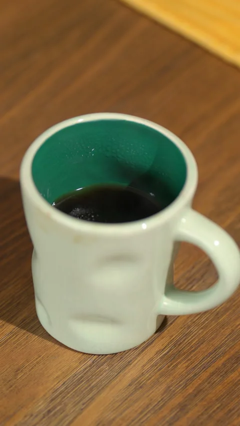Hot steaming coffee in ceramic mug on wooden table Stock Footage 312402068