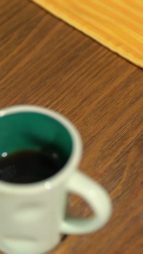 Hot steaming coffee in ceramic mug on wooden table Stock Footage 312402414