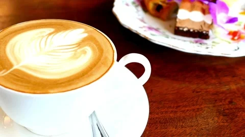 Hot steaming cup of coffee standing on a wooden table. morning coffee concept. 動画素材 334651032