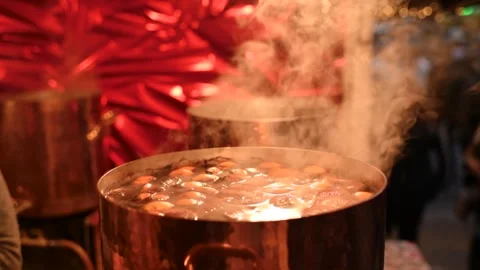 Hot, steaming mulled wine simmers in a large pot at a Christmas market in Rouen Stock Footage 303187659