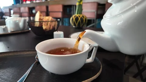 Hot steaming tea being poured from a white teapot. Stock Footage 317629899