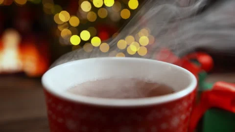 Hot Steaming Tea in Red Cup with Blurred Fireplace in Background on Christmas Stock Footage 208932167