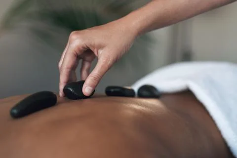 Hot stones rejuvenate the body. Closeups shot of an unrecognisable woman getting Stock Photos
