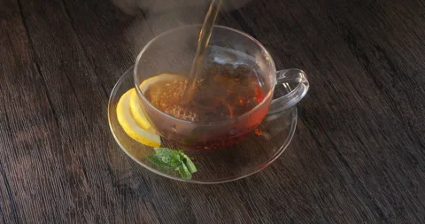 Hot tea being poured into a clear cup Vidéo 262580616