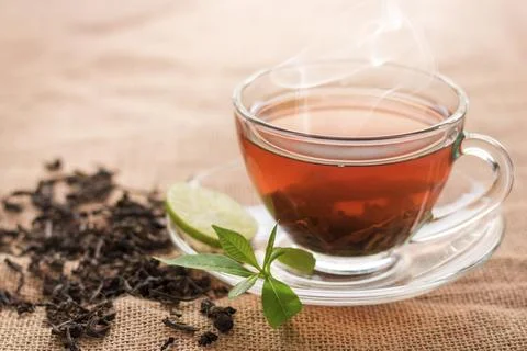Hot tea of cup with slice of lemon on hemp sack for break fast and drinking.. Stock Photos