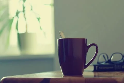 Hot tea cup on the table, window background, cozy home Foto stock