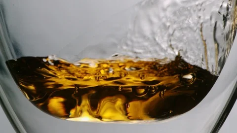 Hot tea flowing into transparent cup in slowmotion Stock Footage 99701558