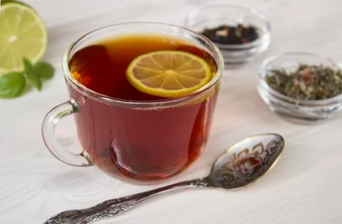Hot tea with lime in a cup Stock Photos