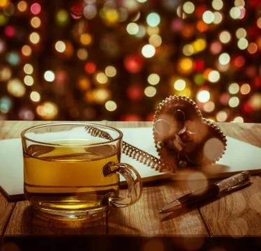 Hot tea with notebook, pen and heart gift on wooden table Stock Photos