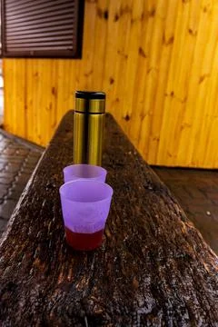 Hot Tea in Plastic Cups and Thermos on Rustic Wooden Bench Fotos de archivo