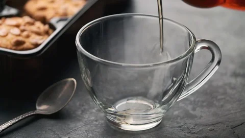 Hot tea is poured into a transparent cup and slowly emits steam Stock Footage 129236196