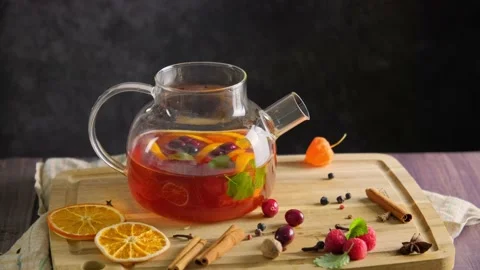 Hot tea with raspberry, orange fruit and herbs brewing in transparent glass Stock Footage 222629914