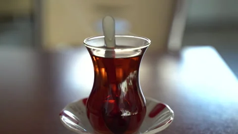 Hot Turkish tea cup on the table on sunny day close up Stock Footage 274926172