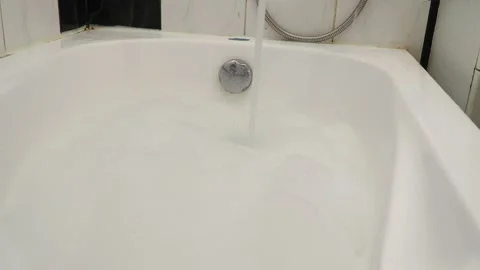 Hot water for bathing, fluffy white foam is drawn from the tap into the bath Stock Footage 150517944