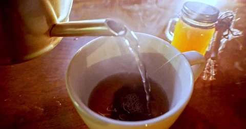 Hot water being poured into tea cup with tea bag wide angle Stock Footage