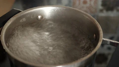 Hot water is boiling in a pot, bubbling up Vídeo Stock 136948441
