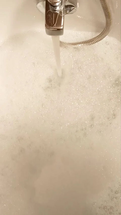 Hot water flowing into a bubble bath Stock Footage 321020993