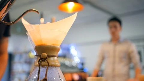 Hot water poured into filter to brew specialty coffee while a client is waiting Vídeo Stock 101737452
