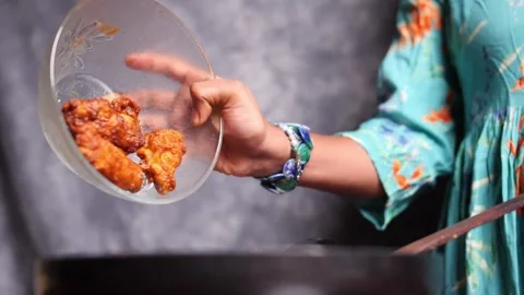 Hot Wings Falling into Pan Stock Footage 135019212