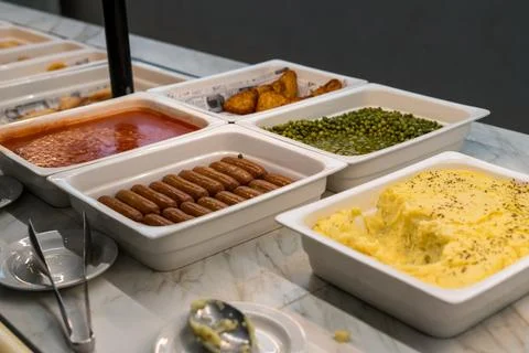 Hotel buffet with sausages mashed potatoes peas and tomato sauce Stock Photos