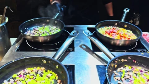 The hotel chef prepares scrambled eggs to order at breakfast Stock-Footage 257775009