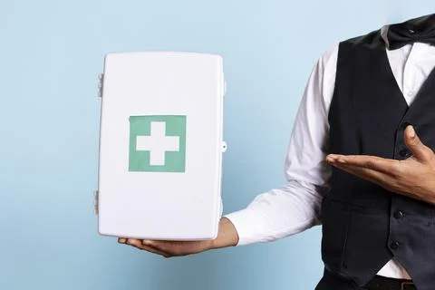 Hotel concierge doorman pointing at a first aid kit used for medical purposes Foto stock