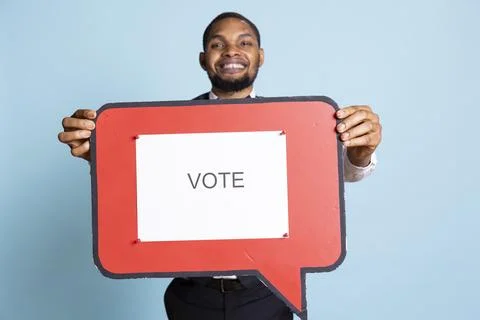 Hotel concierge holding a speech bubble with the message to vote Stock Photos