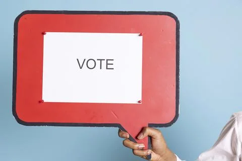 Hotel concierge holding a speech bubble with the message to vote Stock Photos