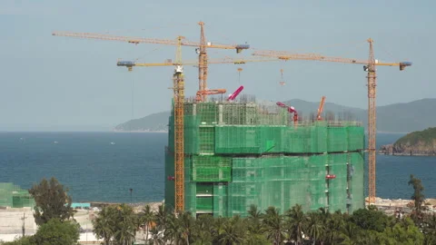 Hotel construction site with tower cranes on sea coast Stock Footage 163138107