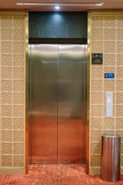 Hotel elevator doors with a trash can positioned right next to them Foto stock