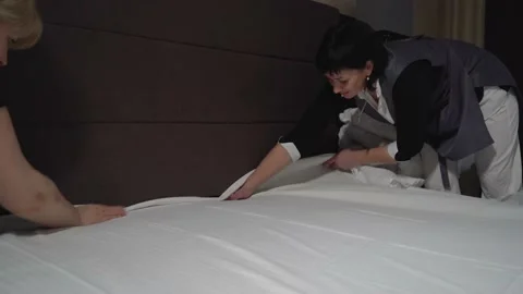 Hotel employees preparing clean bed linen Vídeos de archivo 148486175