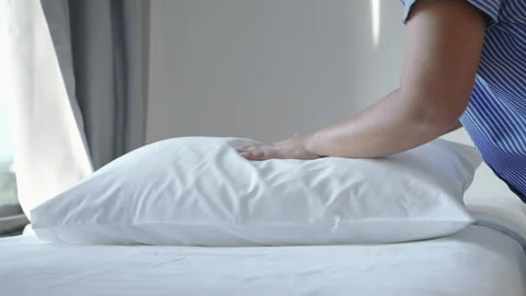 Hotel housekeeper is making the bed and arranging the pillows. Stock Footage 275367796