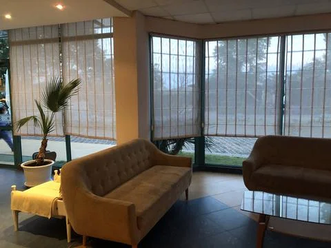 Hotel lobby with sofas, table and panoramic windows. Stock Photos