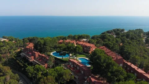 Hotel nestled among trees with a pool by the ocean, stunning aerial view Stock Footage 268451497