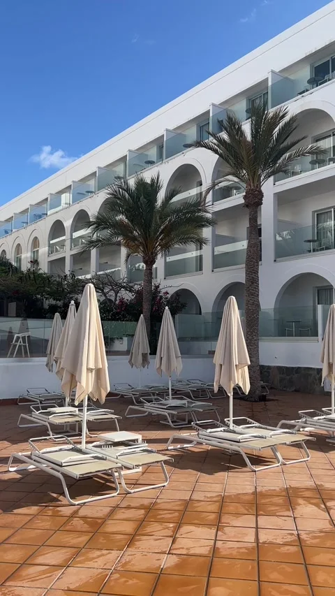 Hotel pool sunbeds umbrellas white resort architecture Fuerteventura HD vertical 스톡 동영상 342027796