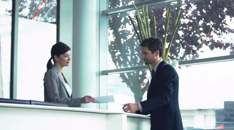 Hotel receptionist handing document to customer Video stock 63279063