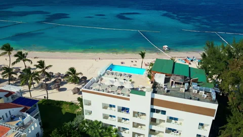 A hotel with a rooftop pool on the oceanfront. Bright sunny day in Punta Cana Video stock 309584686