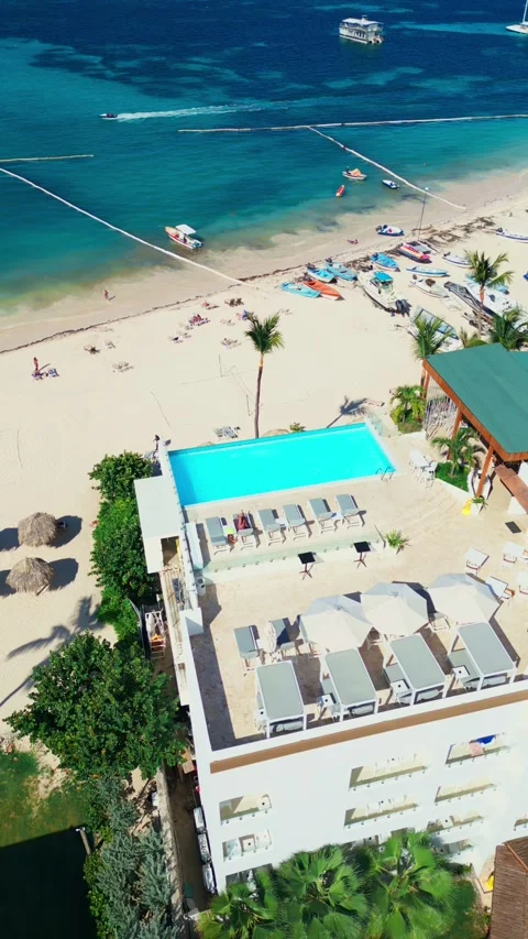 A hotel with a rooftop pool on the oceanfront. Bright sunny day in Punta Cana Stock Footage 309812487