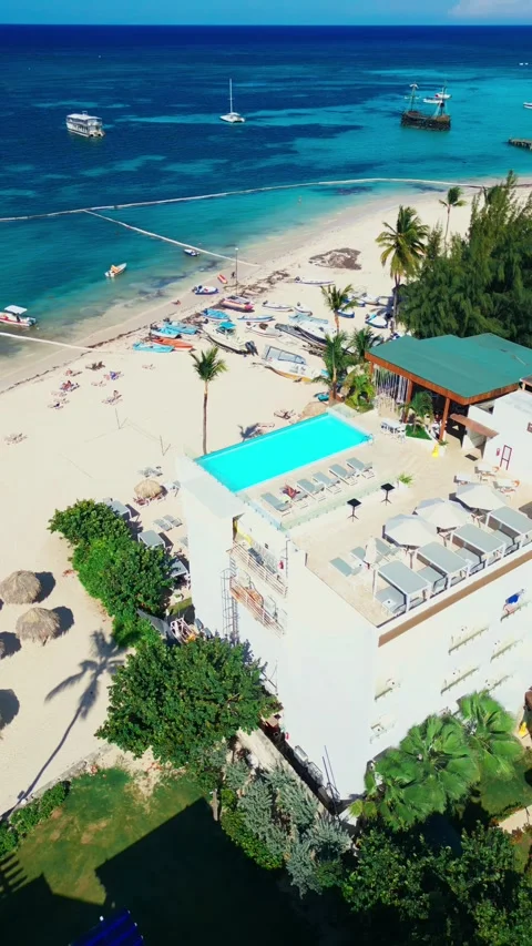 A hotel with a rooftop pool on the oceanfront. Bright sunny day in Punta Cana Stock Footage 309812755