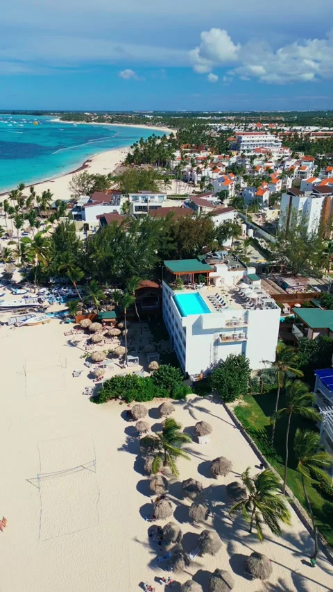 A hotel with a rooftop pool on the oceanfront. Bright sunny day in Punta Cana Stock Footage 309812792