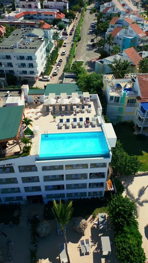 A hotel with a rooftop pool on the oceanfront. Bright sunny day in Punta Cana Stock Footage 309940321