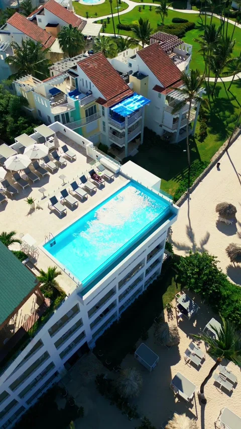 A hotel with a rooftop pool on the oceanfront. Bright sunny day in Punta Cana Stock Footage 309940346