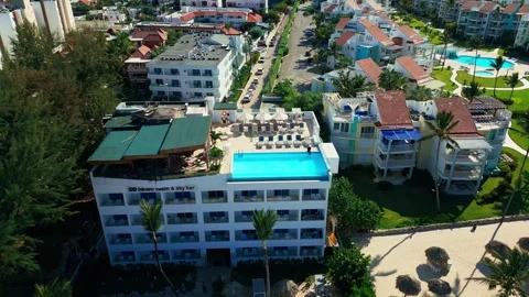 A hotel with a rooftop pool on the oceanfront. Bright sunny day in Punta Cana Stock Footage 309940571