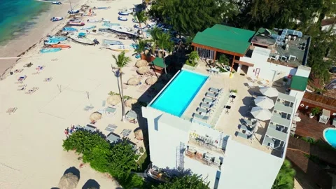 A hotel with a rooftop pool on the oceanfront. Bright sunny day in Punta Cana Stock Footage 309942140