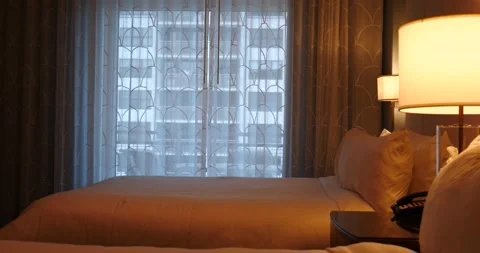 Hotel room with light coming through curtains slider movement across bed Stock Footage 210316142