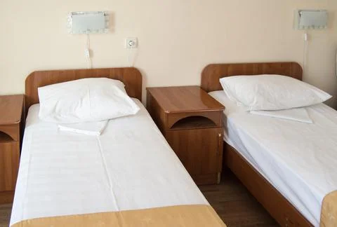 Hotel room with two empty SINGLE beds and bedside tables, the concept of the  Stock Photos