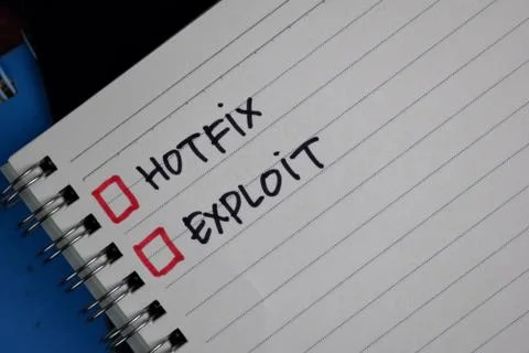 Hotfix and Exploit write on a book. Supported by an additional services Stock Photos