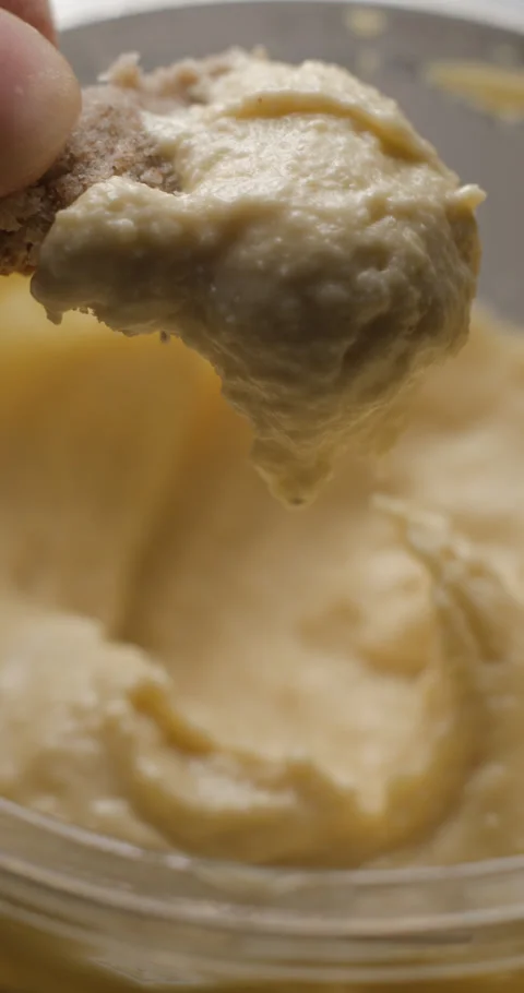 Houmous bread dipping close-up slow motion, vertical view Stock Footage 280520811