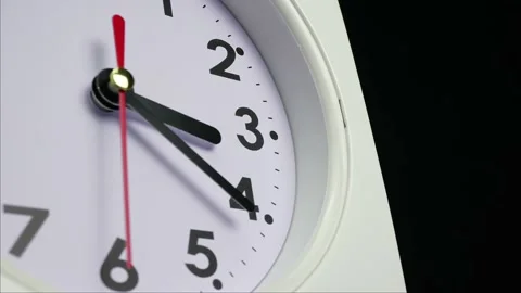 The hour hand on the white clock points between the three and four digits. Stock Footage 230114704