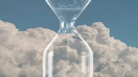 Hourglass on the background of fast moving clouds. Time is running out. memento  Stock Footage 133715792